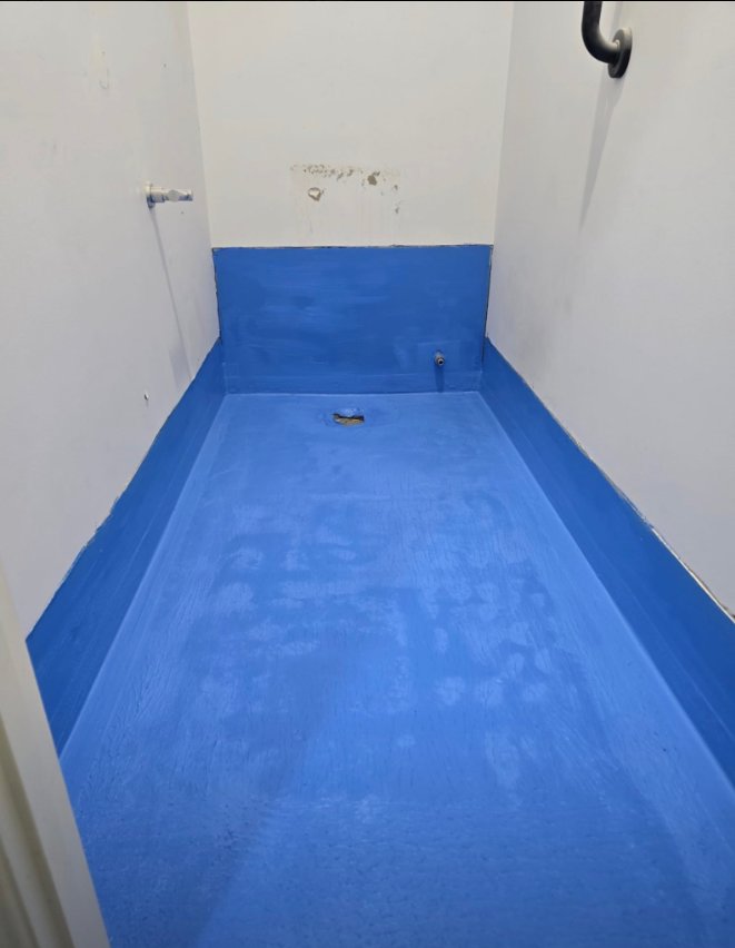 Blue waterproofing membrane on floor and lower walls of a wet area